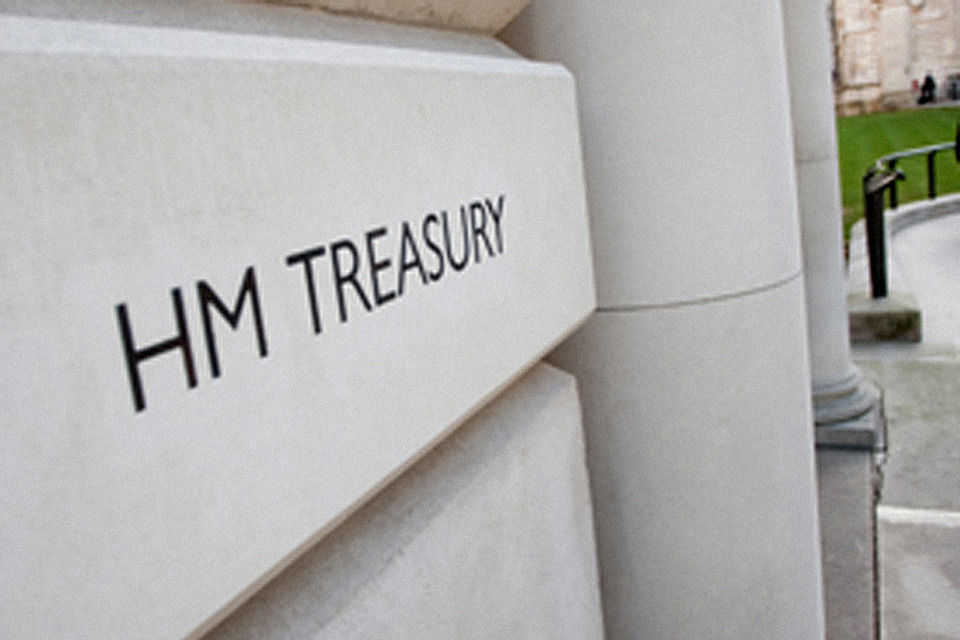 Stone facade of HM Treasury with the department name in black capital letters beside classical columns
