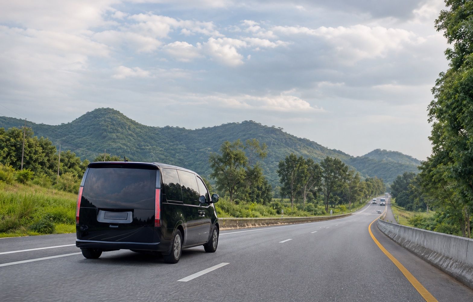Private passenger vehicle travelling on an intercity road through a green landscape in Thailand