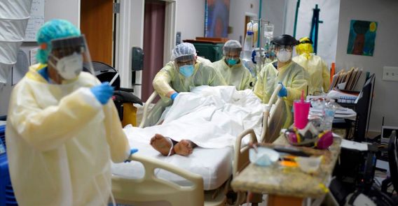 Healthcare workers move a patient in the Covid-19 Unit at United Memorial Medical Center in Houston, Texas