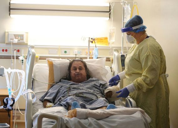 Memorial Hospital nurse Angela Bilyeu flushes the IV of patient Pedro Cortez in a COVID-19 unit on Friday | Alex Horvath