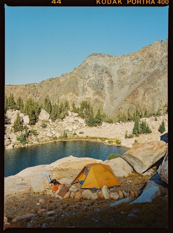 FRAME 12 — Camp for the night, nestled into a cliff edge overlooking an alpine lake. Not too shabby. 