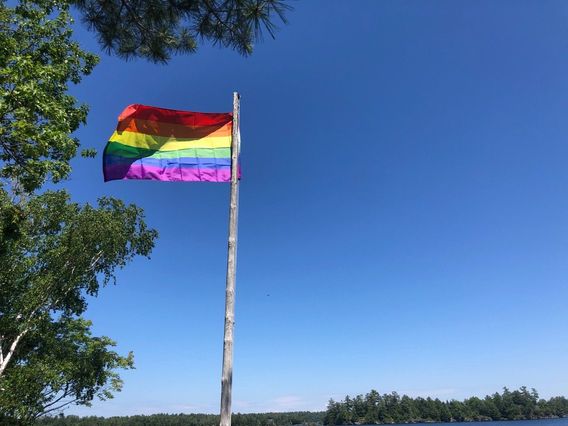 Pride flag flying over Six Mile Lake