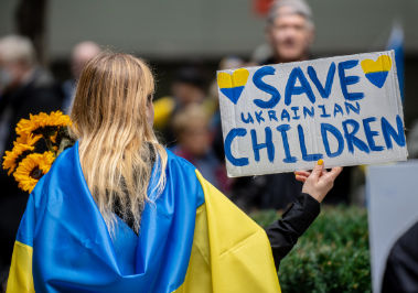 Protester Holding a Save Ukrainian Children Sign