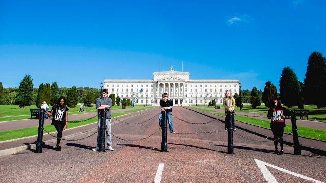 A group of young people standing outside stormont