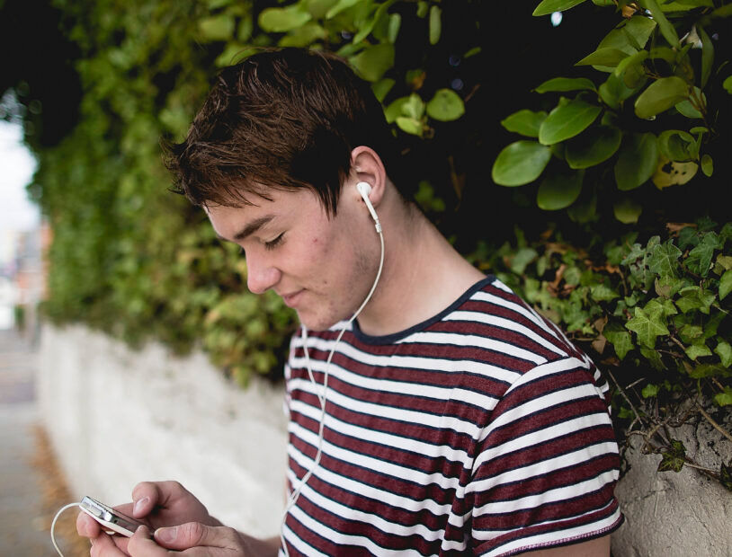 Teenager Looking at Phone with Earphones