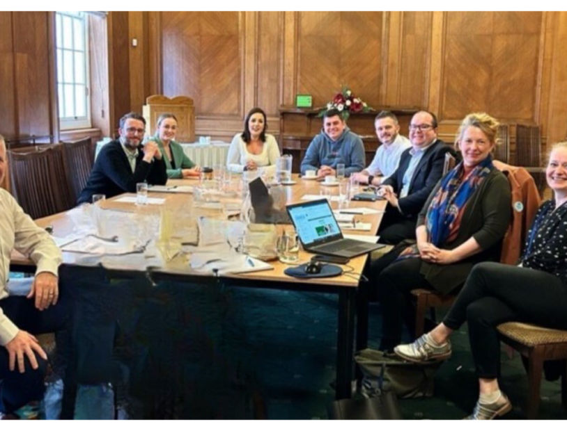 Group of people sitting round a table.