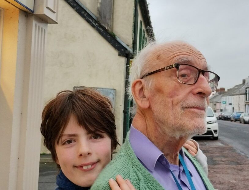 Young boy with his arms round his grandfather.