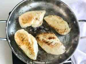 chicken breasts browning in a pan