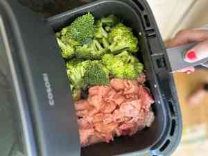 Shaved beef and raw broccoli in an air-fryer