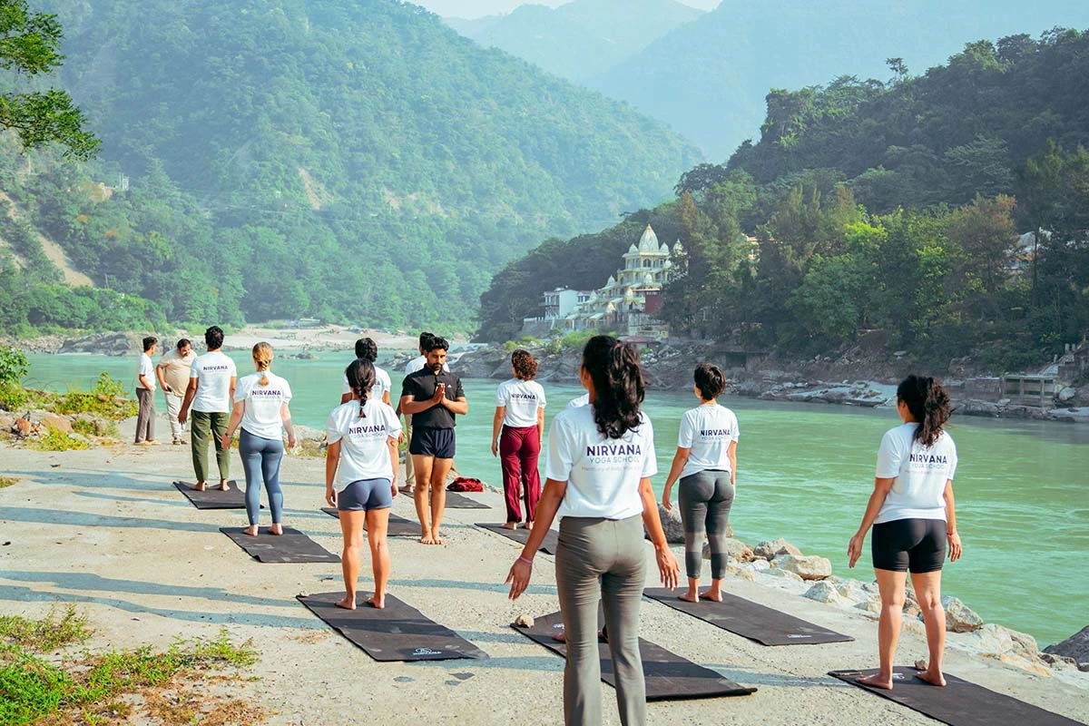 Students practicing yoga near the Ganga