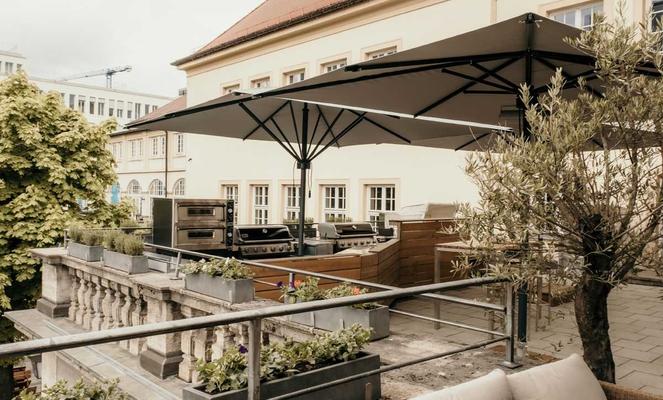 Ein Außenbereich einer Bar in der Innenstadt mit braunen Sonnenschirmen