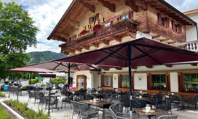 Hotel Bruggerhof mit roten Sonnenschirmen