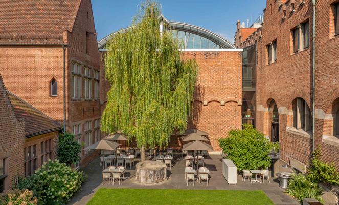 Backsteinhaus mit einer Terrasse und braunen Sonnenschirmen