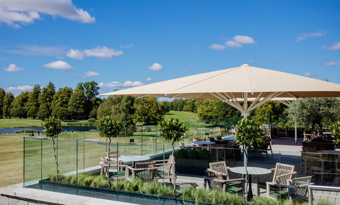 Terrasse mit Stühlen und beigen Sonnenschirmen