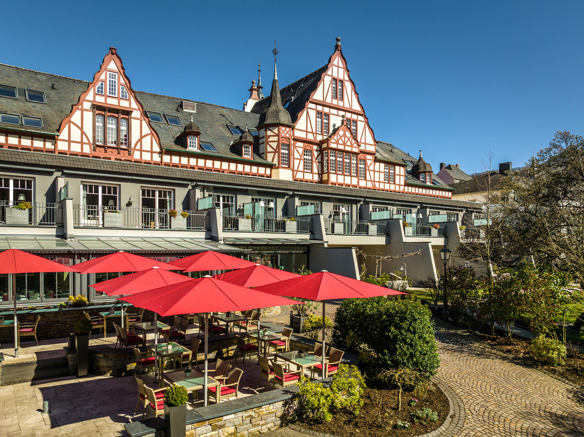 Rote Sonnenschirme vor einem Wellnesshotel