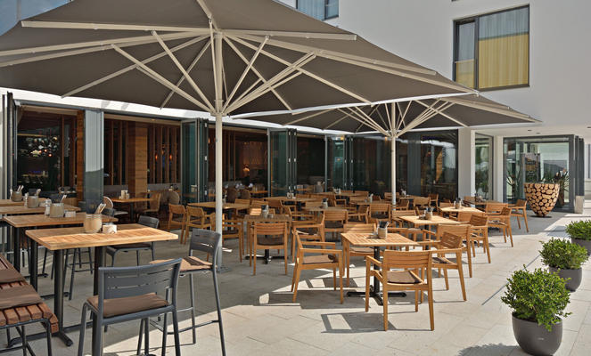 Terasse von einem Gasthaus mit zwei braunen Sonnenschirmen