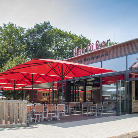 Outdoor patio at the restaurant Barfüßer with red MAY SCHATTELLO parasols