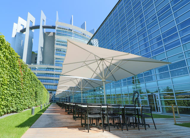 Beige giant parasols, square, on a patio of the European parliament