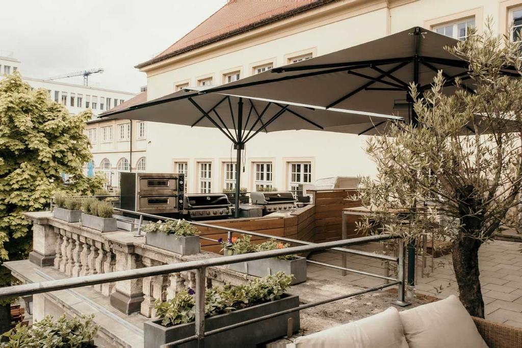 Bar Ludwig mit braunen ALBATROS Schirmen Ein Außenbereich einer Bar in der Innenstadt mit braunen Sonnenschirmen