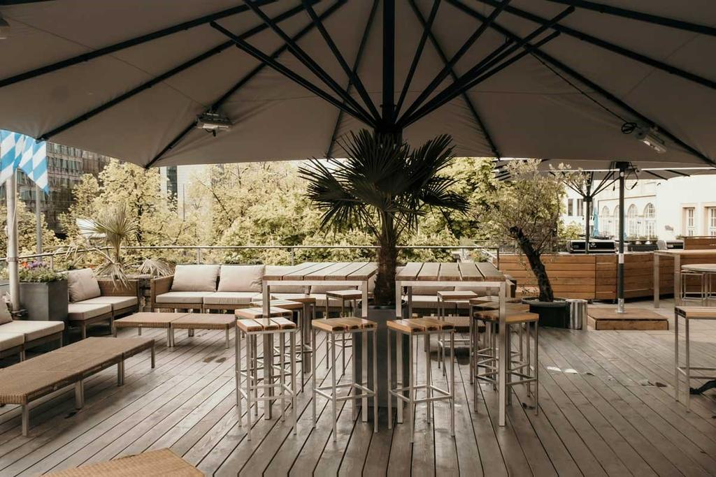 Bar Ludwig mit braunen ALBATROS Schirmen Ein Außenbereich einer Bar in der Innenstadt mit braunen Sonnenschirmen