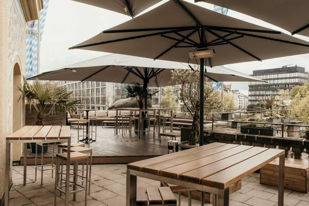 Bar Ludwig mit braunen ALBATROS Schirmen Ein Außenbereich einer Bar in der Innenstadt mit braunen Sonnenschirmen