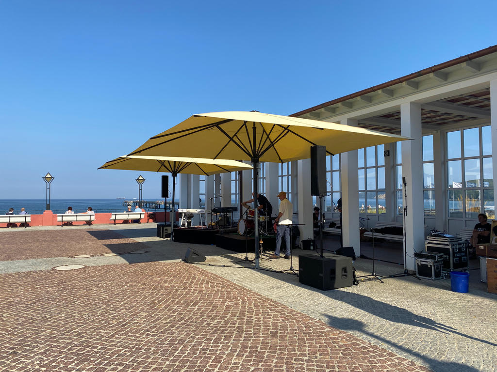 Binzer Bucht in Binz Deutschland mit gelben SCHATTELLO Schirmen Öffentlicher Platz mit gelben Sonnenschirmen