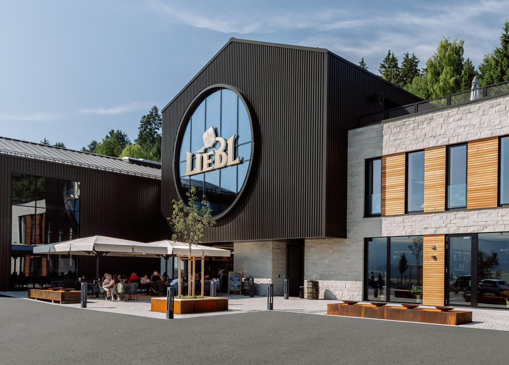 Modern distillery with terrace and white parasols.