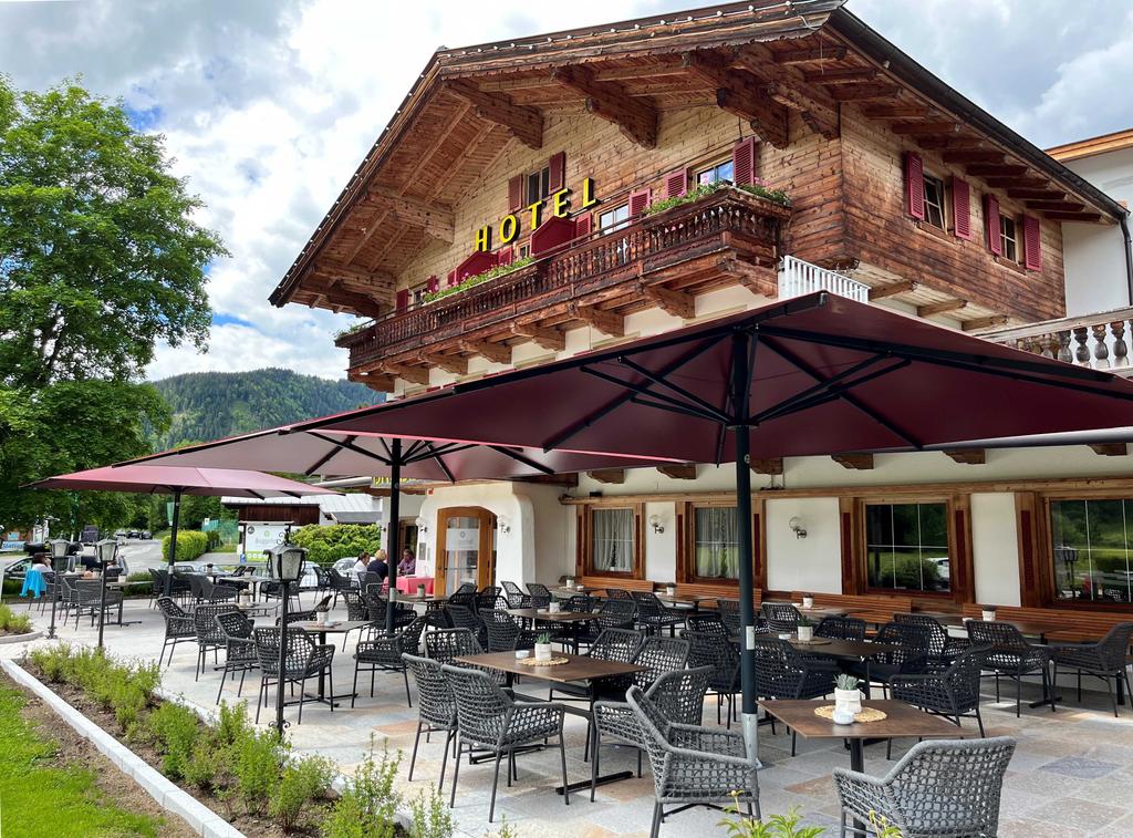 Bruggerhof, Kitzbühel in Österreich mit roten ALBATROS Schirmen Hotel Bruggerhof mit roten Sonnenschirmen