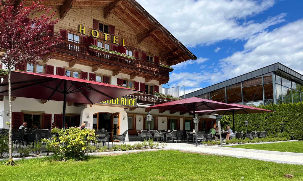 Bruggerhof, Kitzbühel in Österreich mit roten ALBATROS Schirmen Hotel Bruggerhof mit roten Sonnenschirmen