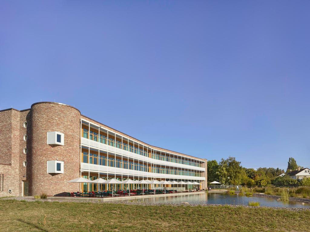 DM Headquarter Drugstore, Karlsruhe with white SCHATTELLO parasols Modern building with terrace by the water and white parasols