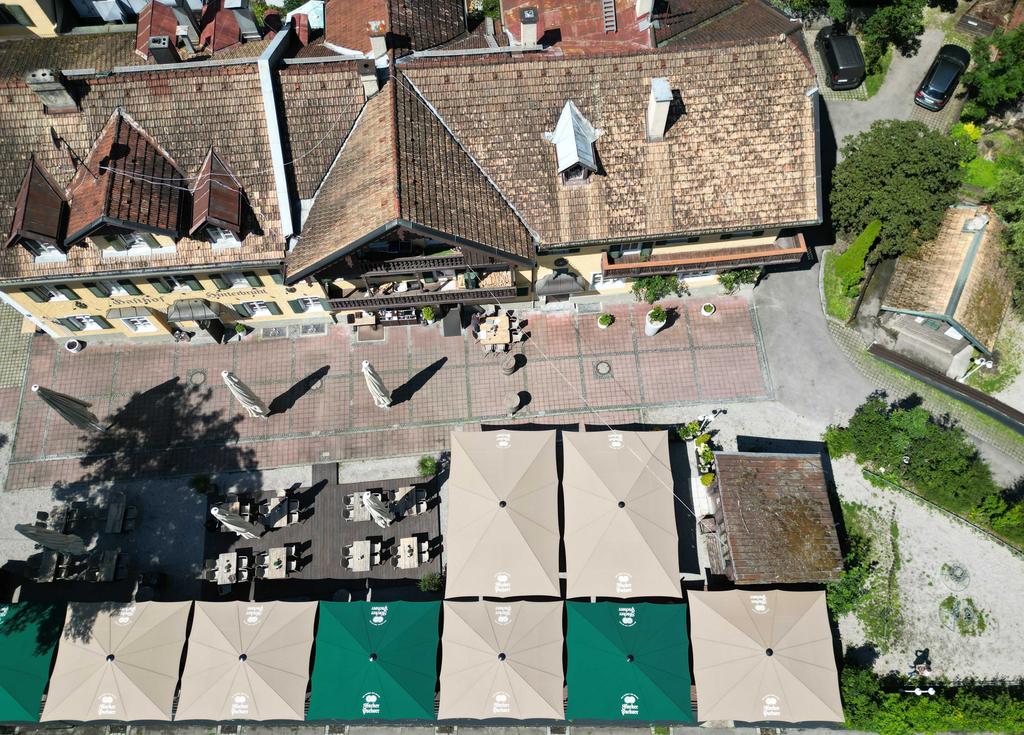 Gasthof Hinterbrühl am See, Munich with brown and green ALBATROS parasols A terrace with green and brown parasols