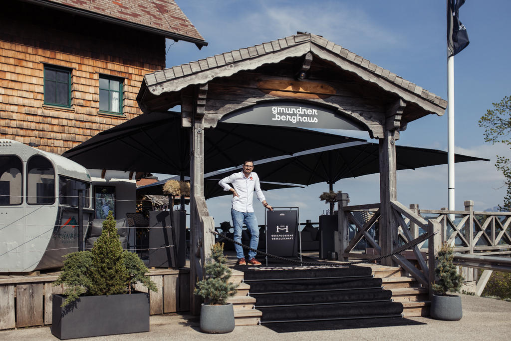 Gmundnerberghaus with gray ALBATROS umbrellas Wooden house with terrace and grey parasols