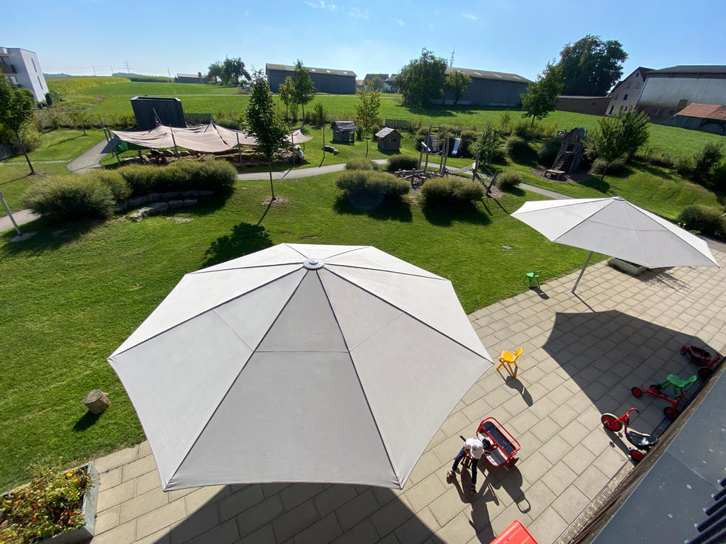 White parasols on a terrace and lawn