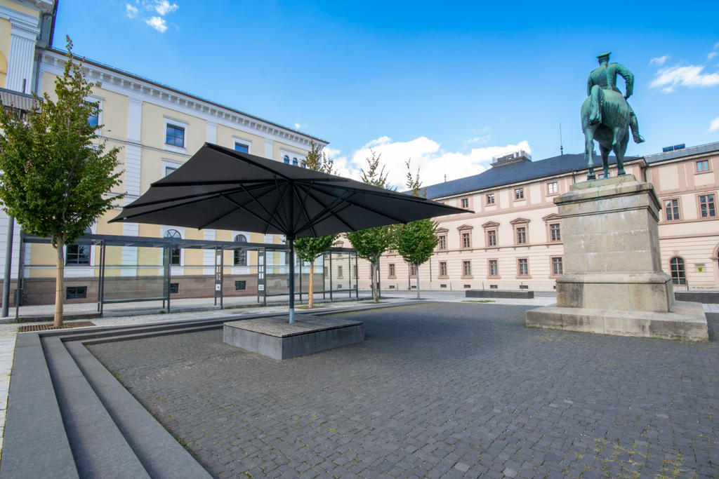 Öffentlicher Platz mit einem dunklen Sonnenschirm