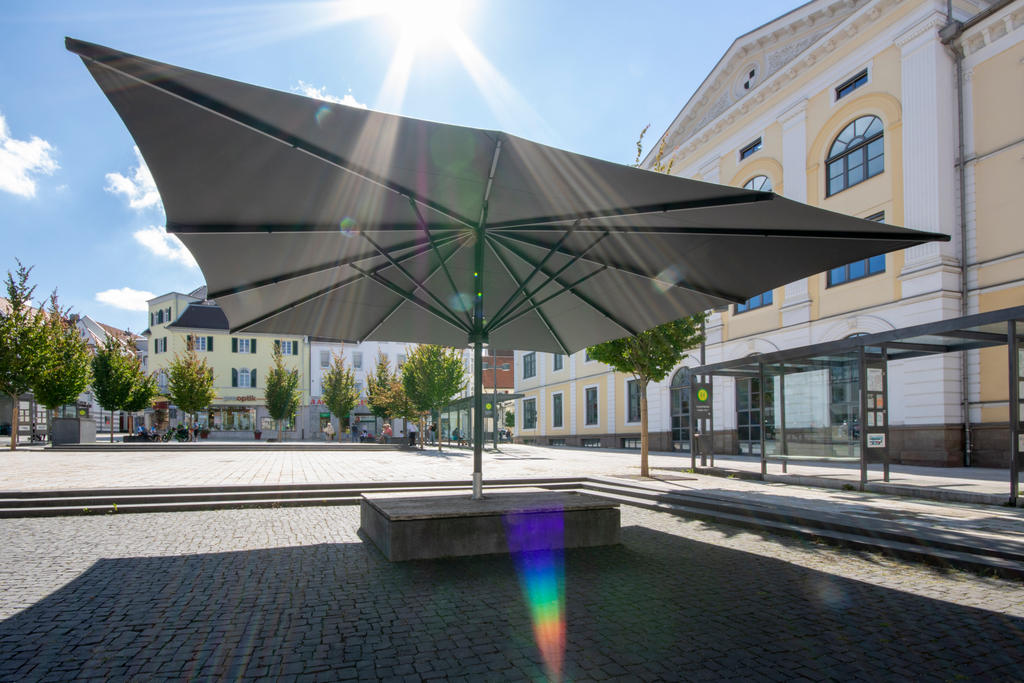 Öffentlicher Platz mit einem dunklen Sonnenschirm