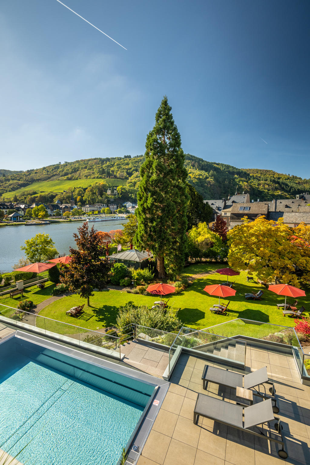 Moselschlösschen mit roten FILIUS Schirmen Rote Sonnenschirme vor einem Wellnesshotel