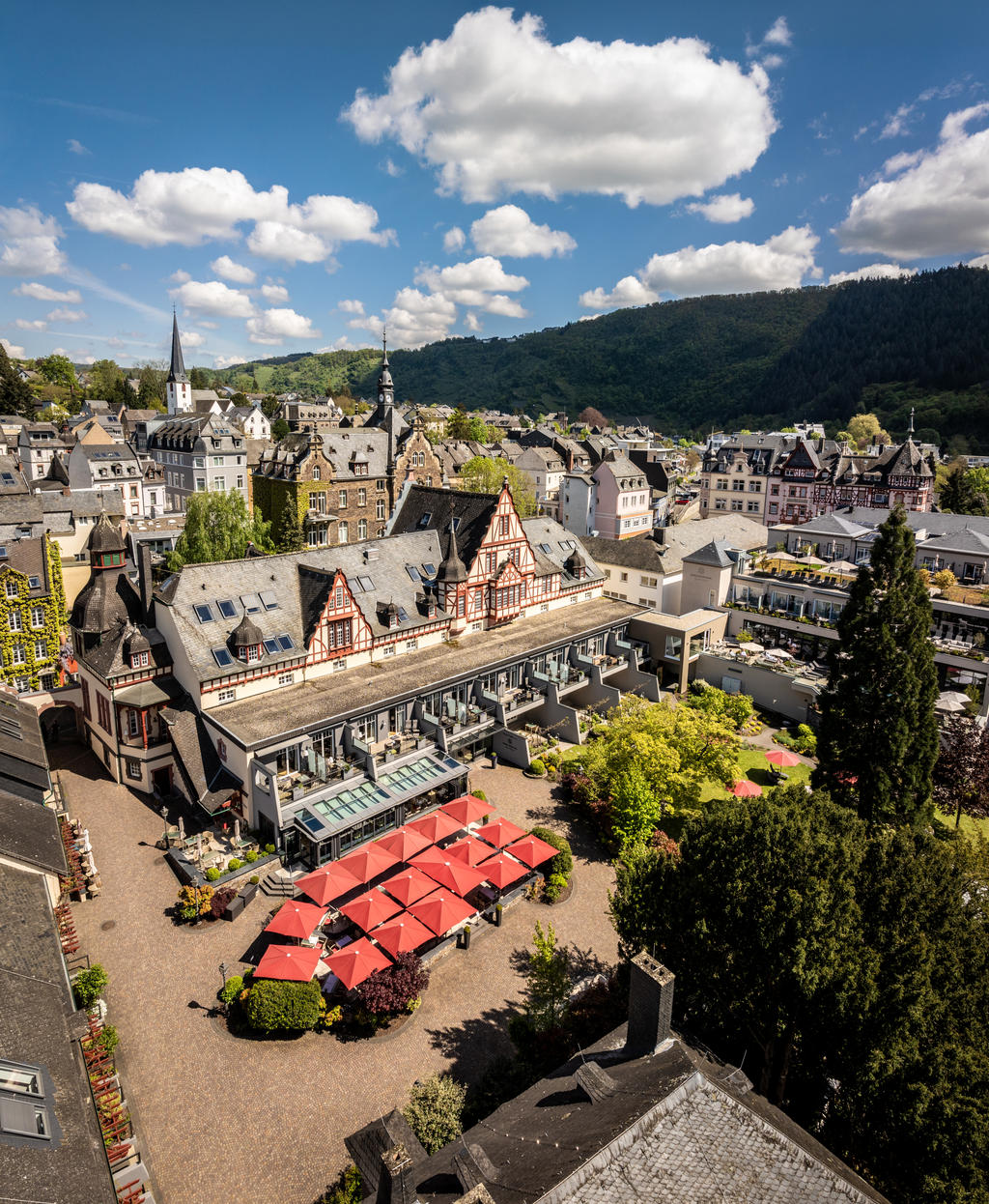 Moselschlösschen mit roten FILIUS Schirmen Rote Sonnenschirme vor einem Wellnesshotel