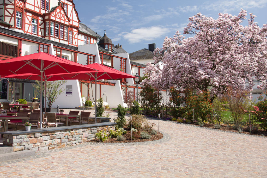 Moselschlösschen Traben-Trarbach mit roten FILIUS Schirmen Terrasse mit roten Sonnenschirmen