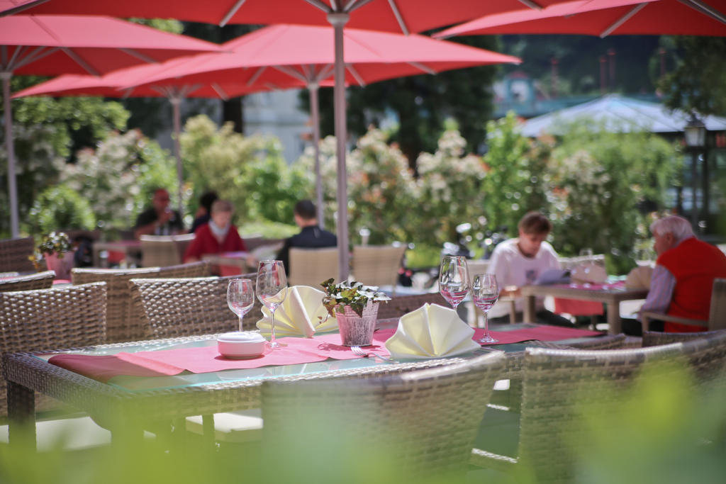 Terrasse im grünen mit roten Sonnenschirmen