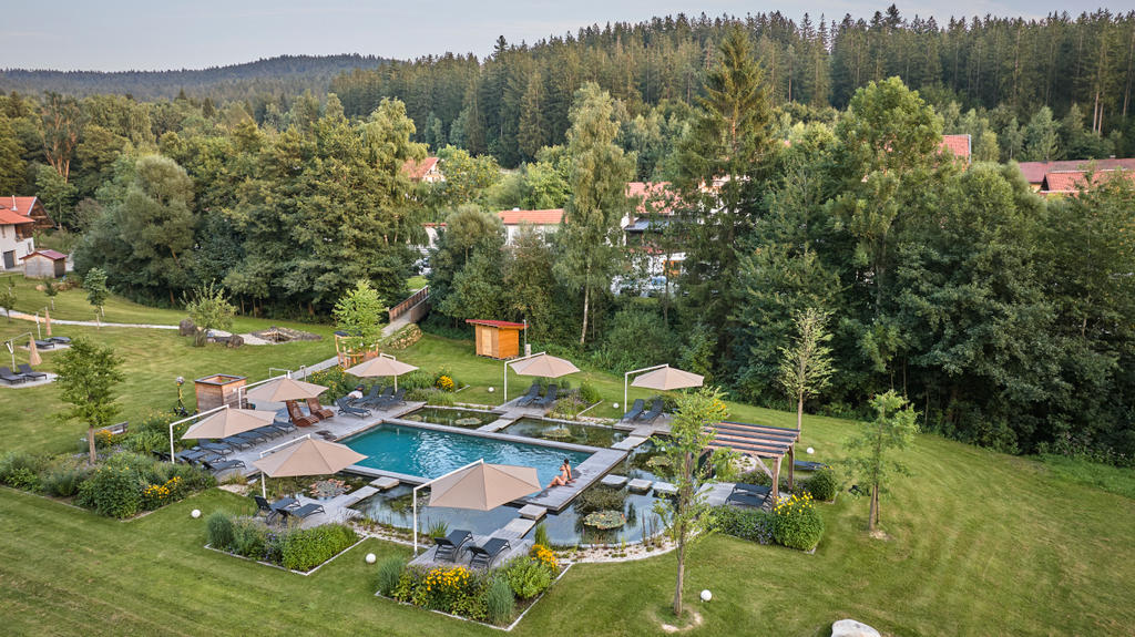Hotelgarten mit beigen Sonnenschirmen