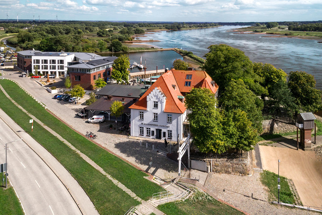 Zollenspieker Fährhaus mit weißen ALBATROS Schirmen Gastronomie-Terrasse an einem See mit Sonnenschirmen