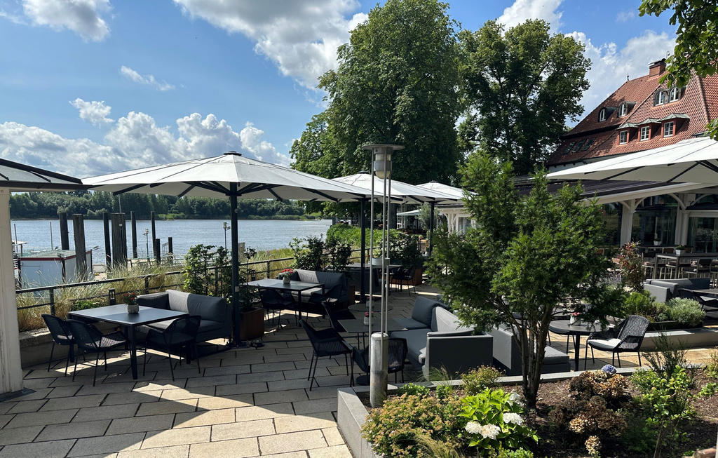 Zollenspieker Fährhaus mit weißen ALBATROS Schirmen Gastronomie-Terrasse an einem See mit Sonnenschirmen