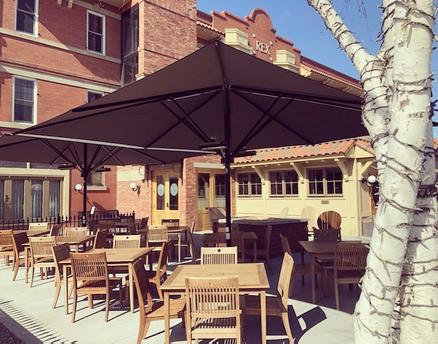 Buffalo Block Prime Steakhouse avec des parasols SCHATTELLO noirs Bâtiment en briques avec une terrasse et des parasols noirs