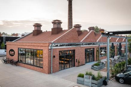 Genusshöfe Osnabrück avec des parasols SCHATTELLO noirs. Maison en briques avec terrasse et parasols noirs