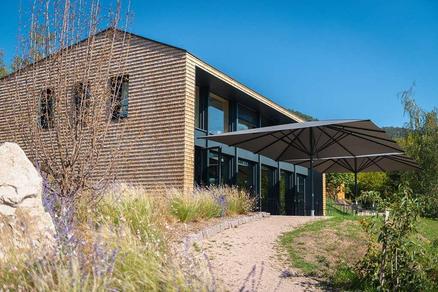 Hôtel 48° Nord avec des parasols ALBATROS marron Maison en bois avec une terrasse et des parasols marron