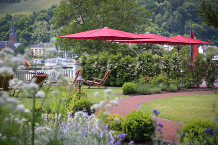 Terrasse im grünen mit roten Sonnenschirmen