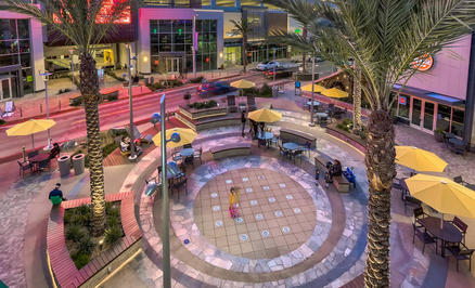 Noho West avec des parasols FILIUS jaunes Un campus avec des boutiques et un espace extérieur avec des parasols