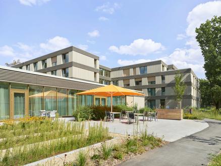 Hotel terrace with orange Parasol and cozy seating areas outdoors.