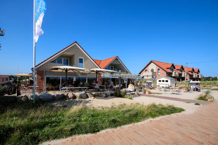 Strandterrasse mit weißen Sonnenschirmen