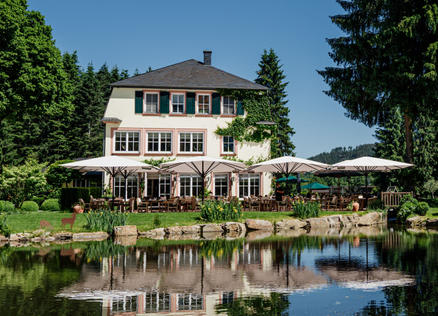 Rüssels Landhaus with white SCHATTELLO shades A house on a lake with white parasols